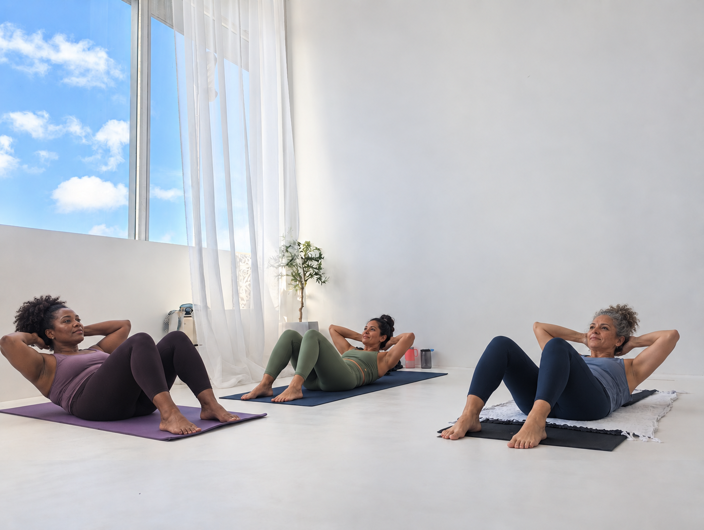 A woman practicing a controlled core exercise on a mat in a bright Barbados movement studio.